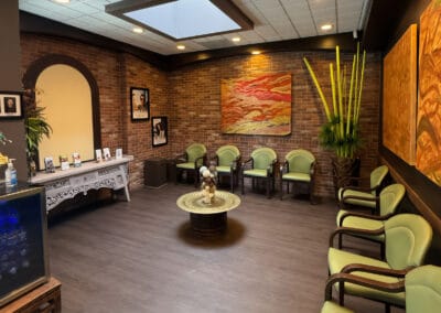 Spacious lobby and waiting area at Better Life Dental Implant Center with seating, artwork, and brick walls