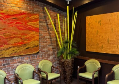 Comfortable waiting area at Better Life Dental Implant Center with chairs, artwork, and decorative plants