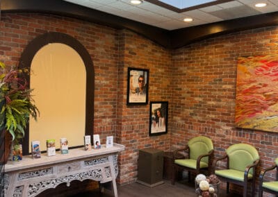 Welcoming lobby of Better Life Dental Implant Center with brick walls, seating area, and patient information display